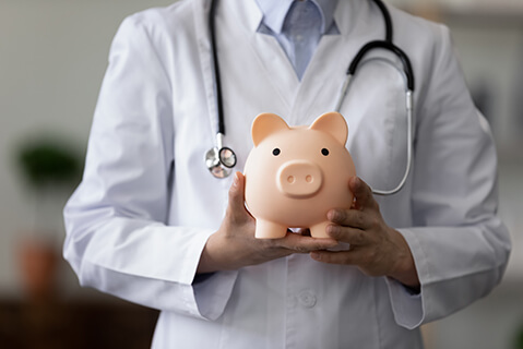 Doctor holding a piggy bank