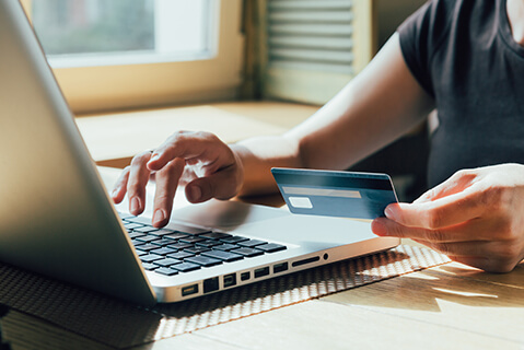 Hands with credit card typing on a computer